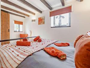 a bedroom with a bed with orange pillows on it at 4 Bed in Bodmin oc-90215 in Bodmin
