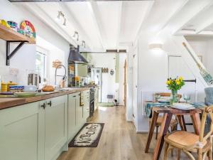 a kitchen with white cabinets and a table and chairs at 1 Bed in Bodmin oc-88165 in Bodmin