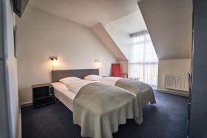 a bedroom with two beds and a large window at Vejlsøhus Hotel and Conference Center in Silkeborg +34 photos