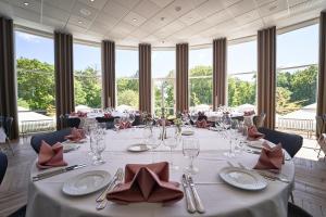 a dining room with a long table with glasses and napkins at Vejlsøhus Hotel and Conference Center in Silkeborg