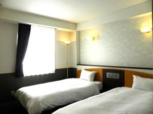 a hotel room with two beds and a window at Hotel Benex Yonezawa in Yonezawa +44 photos