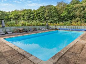 a swimming pool with a patio and a table and chairs at 3 Bed in Saltash oc-30040 in Wotter