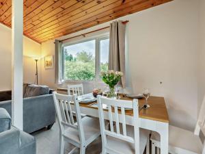 a dining room with a table and chairs and a couch at 3 Bed in Saltash oc-30040 in Wotter