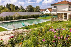 a backyard with a swimming pool and flowers at Golfresort Haugschlag in Haugschlag