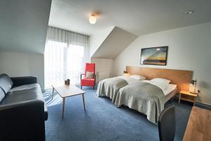 a hotel room with a bed and a couch at Vejlsøhus Hotel and Conference Center in Silkeborg