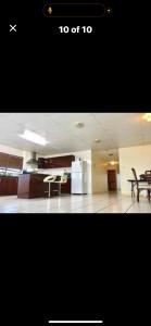 a room with a kitchen with a table and a refrigerator at Less pay for master room in Rosewater