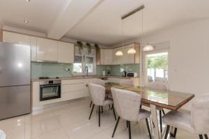 a kitchen with a table and chairs and a refrigerator at Villa Korana with heated Pool & Jacuzzi in Kamenmost +38 photos