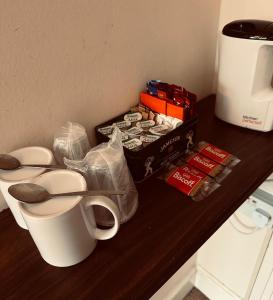 a counter with a coffee cup and a box of cookies at The Lincoln Arms Pub & Rooms in Dorking