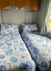 two beds with blue and white covers in a room at Ailsa Seaview in Turnberry +28 photos