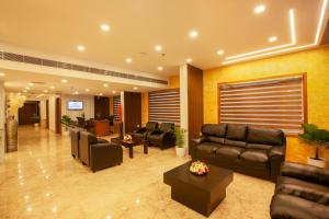 a lobby with couches and chairs in a building at Hotel Laals Inn Grand in Cochin