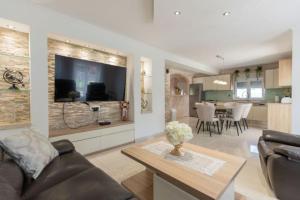 a living room with a couch and a table at Villa Korana with heated Pool & Jacuzzi in Kamenmost