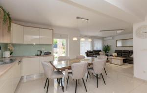 a kitchen and living room with a table and chairs at Villa Korana with heated Pool & Jacuzzi in Kamenmost