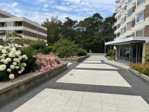 a walkway in front of a building with flowers at Carpe Diem 203 in Niendorf