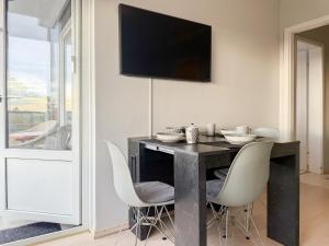 a dining room with a black table and white chairs at Carpe Diem 203 in Niendorf