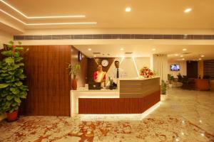 two people standing at a counter in a lobby at Hotel Laals Inn Grand in Cochin