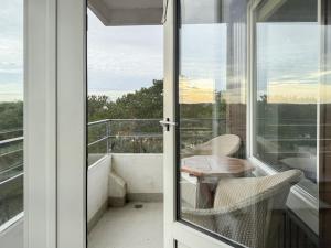 a glass door leading to a balcony with a table and chairs at Carpe Diem 203 in Niendorf +22 photos