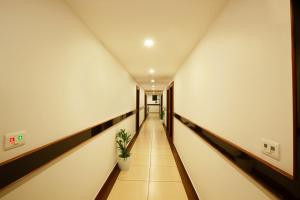 a corridor of an office building with a plant at Hotel Laals Inn Grand in Cochin +17 photos
