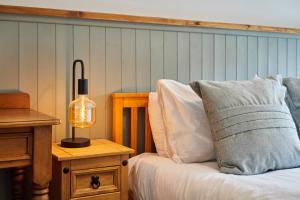 a bedroom with a bed with a lamp on a table at Church View Cottage & Secret Garden, Matlock - Now Hosted by StayHostSave in Matlock