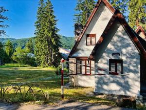 a small house with a gambrel roof at Voineasamountainvillas in Voineasa