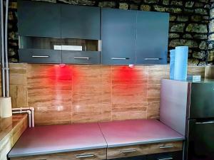 a kitchen with blue cabinets and a purple bench at Voineasamountainvillas in Voineasa