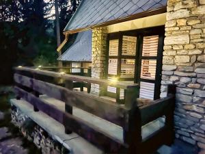 a stone house with a fence in front of it at Voineasamountainvillas in Voineasa +5 photos