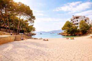 a group of people laying on a beach next to the water at Sa casa des Padrino in Santa Ponsa
