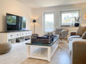 a living room with a tv and a coffee table at Strandbude in Timmendorfer Strand +25 photos