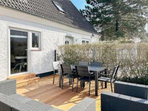 a patio with a table and chairs on a deck at Strandbude in Timmendorfer Strand
