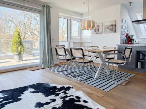 a kitchen and dining room with a table and chairs at Penthouse am Hafen 2 in Niendorf