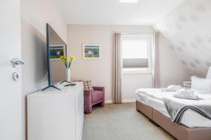 a bedroom with a bed and a dresser with a mirror at Ferienhaus Coordtino in Putbus