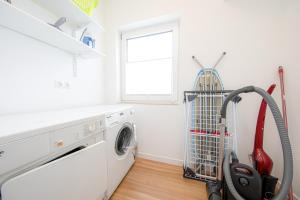a laundry room with a washing machine and a window at Ferienhaus Coordtino in Putbus +20 photos