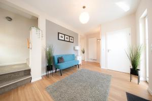 a living room with a blue couch and a rug at Ferienhaus Coordtino in Putbus
