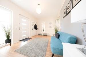 a living room with a blue couch and a rug at Ferienhaus Coordtino in Putbus