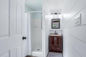 a white bathroom with a sink and a shower at Tiny House on the Hill in New Braunfels