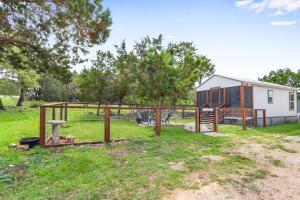 a dog in a fenced in area next to a house at Tiny House on the Hill in New Braunfels +21 photos