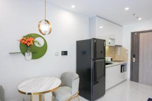a kitchen with a black refrigerator and a table at STUDIO Vinhomes Grand Park , thành phố Hồ Chí Minh in Long Bình