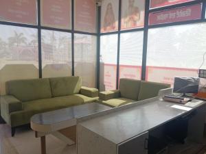 a waiting room with two green couches and a table at Mangaldeep Resort and Garden in Bābai