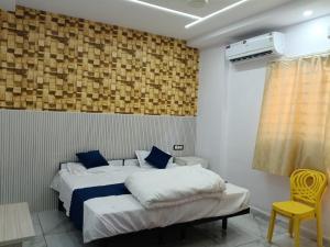 a bedroom with a bed and a yellow chair at Mangaldeep Resort and Garden in Bābai +23 photos