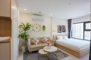 a bedroom with a bed and a couch and a table at STUDIO Vinhomes Grand Park , thành phố Hồ Chí Minh in Long Bình