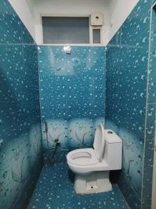 a bathroom with a toilet and a blue wall at M D Guest House in Guwahati