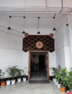 a hallway with potted plants in a building at M D Guest House in Guwahati +11 photos