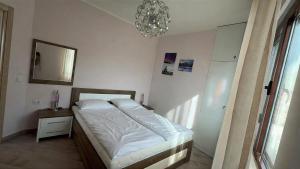 a bedroom with a bed and a mirror and a chandelier at Bella Costa Lux in Dobra Voda +27 photos