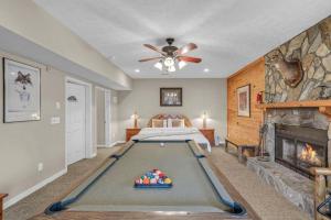 a bedroom with a pool table in front of a fireplace at Scooby Shack in Blowing Rock