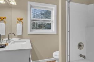 a bathroom with a sink and a toilet and a window at Scooby Shack in Blowing Rock +44 photos