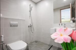 a bathroom with a shower and a toilet and a flower at STUDIO Vinhomes Grand Park , thành phố Hồ Chí Minh in Long Bình +16 photos