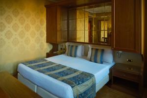 a bedroom with a large bed with a wooden cabinet at Hotel Pensione Wildner in Venice