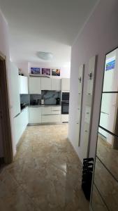 a kitchen with white cabinets and a tile floor at Bella Costa Lux in Dobra Voda