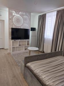 a living room with a couch and a flat screen tv at Hotel Korona in Verbovatovka