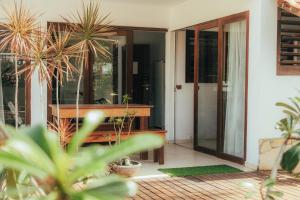 a porch with potted plants and a pivot door at Pipa Panorama Flats&Apartamentos in Pipa