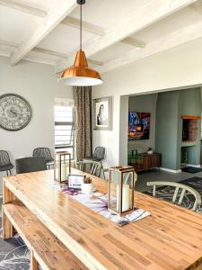 a dining room with a wooden table and a living room at Arc On Ray 31 in Britannia Bay